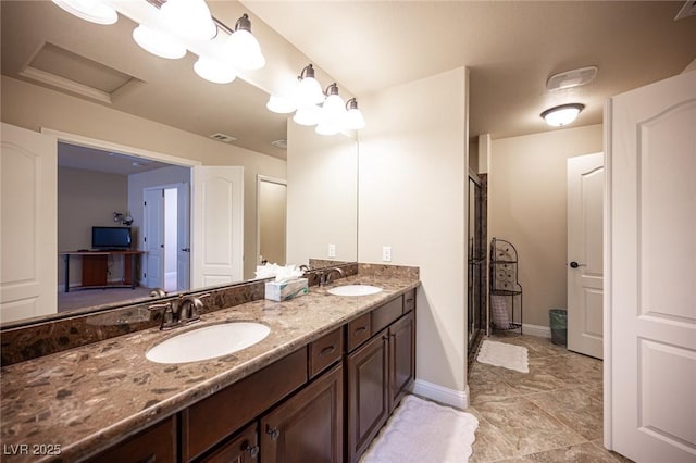 bathroom with a sink, baseboards, double vanity, and visible vents