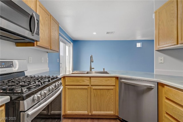 9932 Keephills St, Las Vegas, NV 89183 - kitchen with visible vents, light brown cabinets, light countertops, a sink, and stainless steel appliances