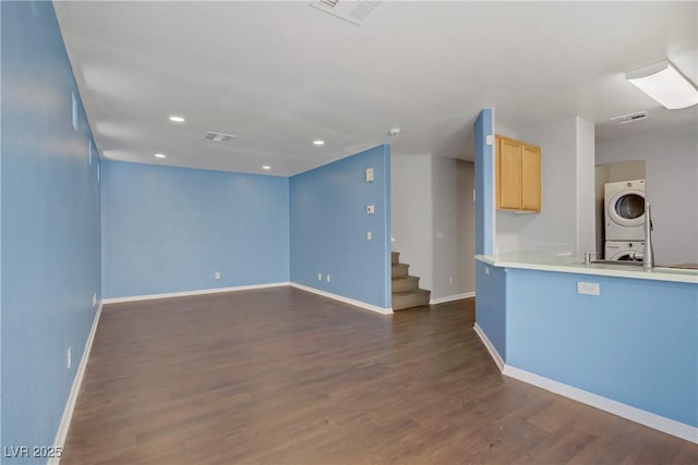 9932 Keephills St, Las Vegas, NV 89183 - kitchen featuring baseboards, light brown cabinets, stacked washer / drying machine, and dark wood-type flooring