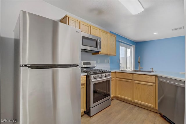 9932 Keephills St, Las Vegas, NV 89183 - kitchen with visible vents, light brown cabinets, a sink, light wood finished floors, and appliances with stainless steel finishes