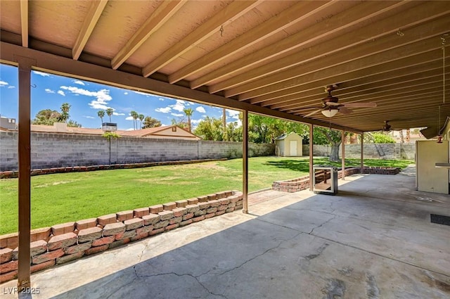 view of patio / terrace with an outbuilding, a fenced backyard, and a storage unit