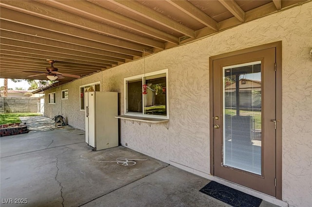 view of patio with ceiling fan and fence