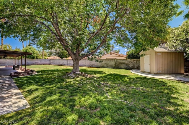 view of yard featuring a fenced backyard, a storage unit, an outdoor structure, and ceiling fan