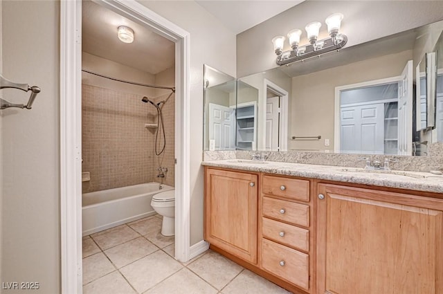 bathroom with double vanity, a sink, tile patterned floors, and toilet