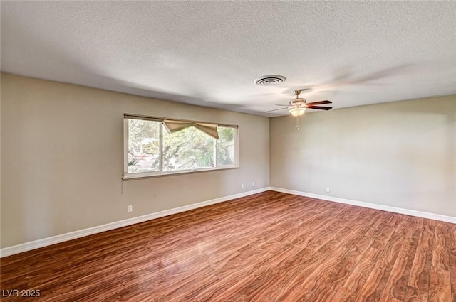 unfurnished room with visible vents, wood finished floors, baseboards, ceiling fan, and a textured ceiling