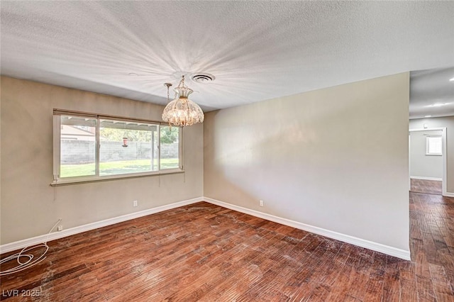 unfurnished room featuring baseboards, dark wood-style flooring, a chandelier, and a healthy amount of sunlight