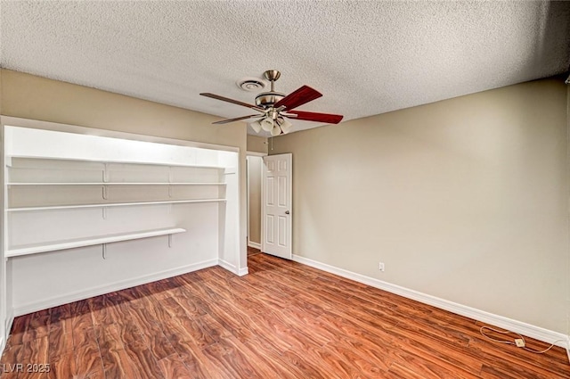 unfurnished bedroom with a closet, wood finished floors, baseboards, a textured ceiling, and a ceiling fan
