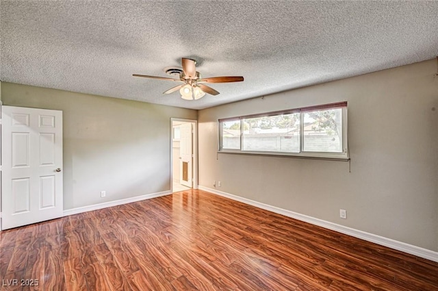 spare room with a textured ceiling, baseboards, a ceiling fan, and wood finished floors