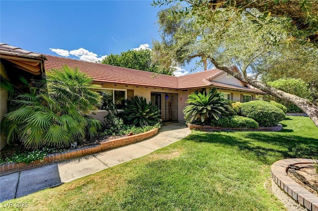 single story home with a tile roof and a front lawn