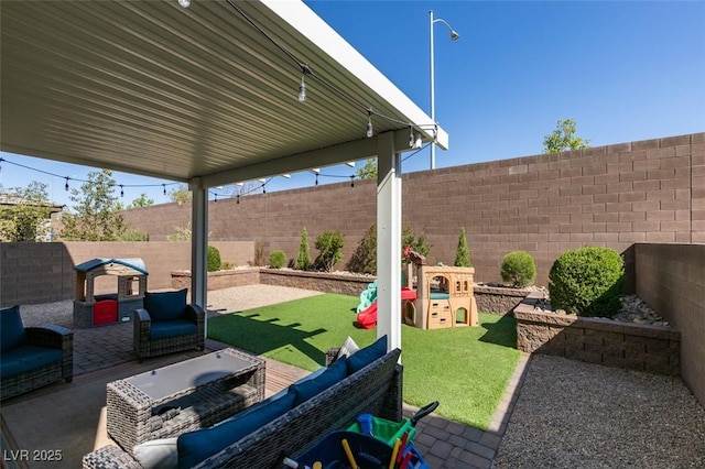 view of patio / terrace featuring an outdoor living space, a fenced backyard, and a playground