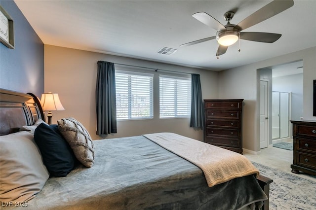 bedroom featuring visible vents, ceiling fan, ensuite bath, and light carpet