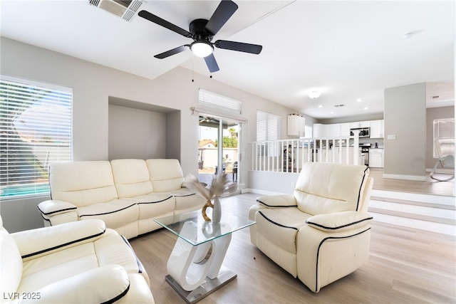 living room featuring visible vents, a ceiling fan, plenty of natural light, and light wood-type flooring