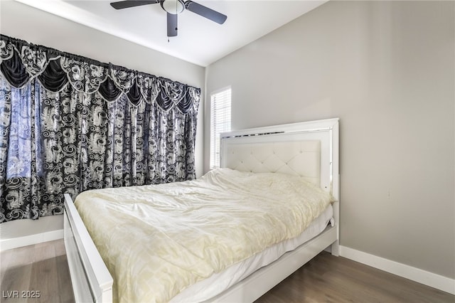 bedroom with baseboards, ceiling fan, wood finished floors, and lofted ceiling