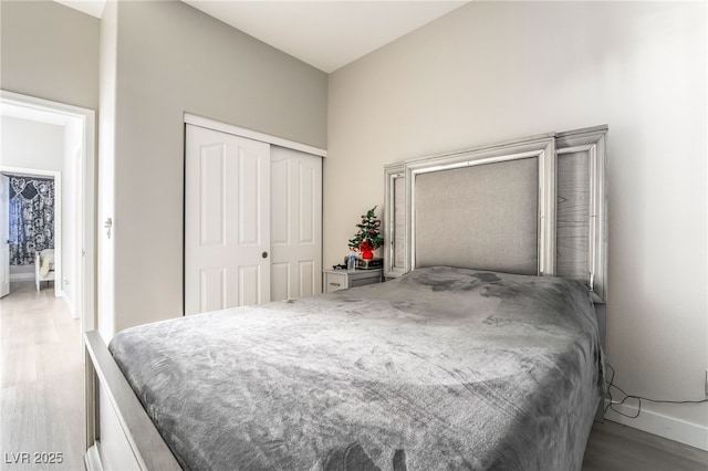 bedroom with baseboards, a closet, and wood finished floors