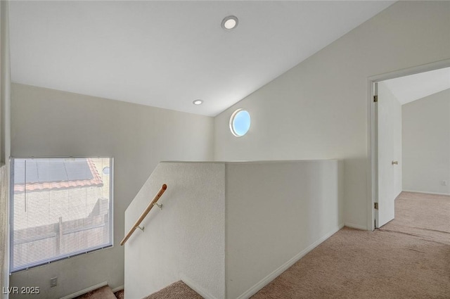 hall with carpet flooring, an upstairs landing, and a healthy amount of sunlight