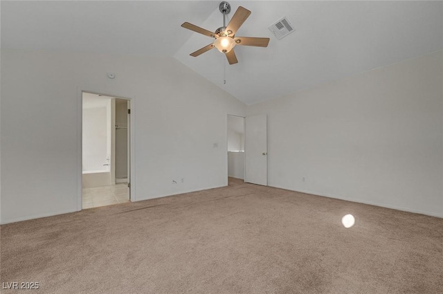 unfurnished bedroom featuring visible vents, light carpet, ensuite bathroom, ceiling fan, and vaulted ceiling