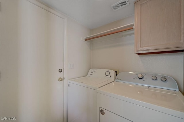 laundry area featuring independent washer and dryer, visible vents, and cabinet space