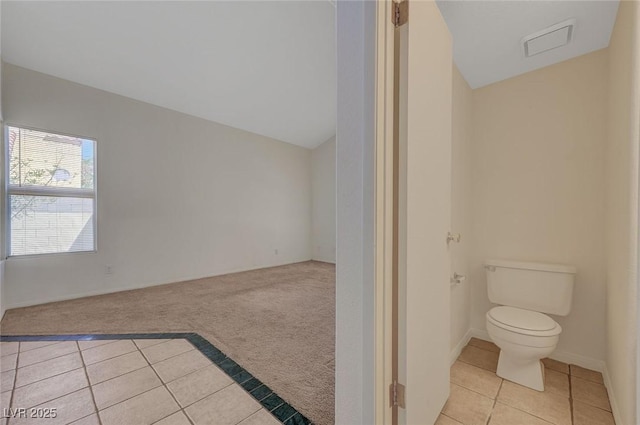 bathroom featuring toilet, tile patterned floors, visible vents, and lofted ceiling