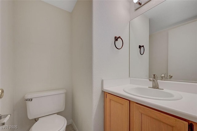 bathroom with vanity, baseboards, and toilet