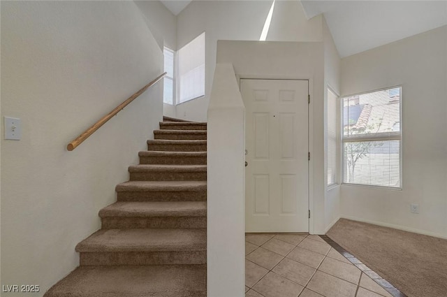 staircase with carpet floors and tile patterned floors