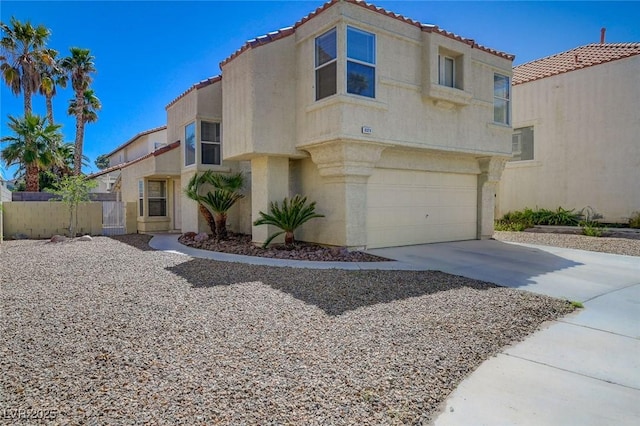 mediterranean / spanish home featuring fence, an attached garage, a tile roof, stucco siding, and driveway
