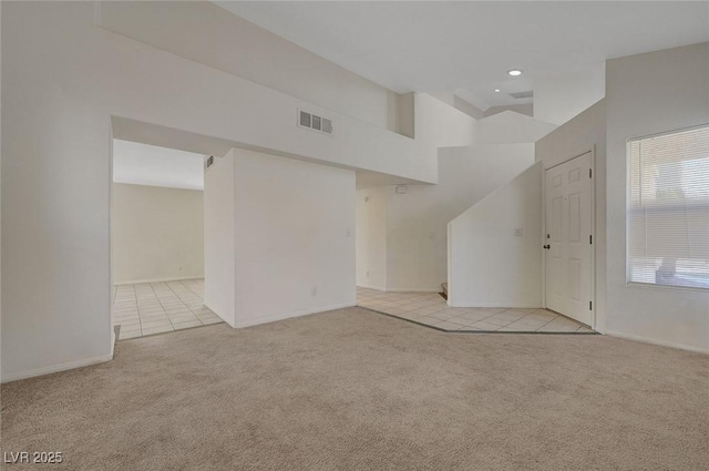 interior space with visible vents, carpet flooring, baseboards, and tile patterned flooring
