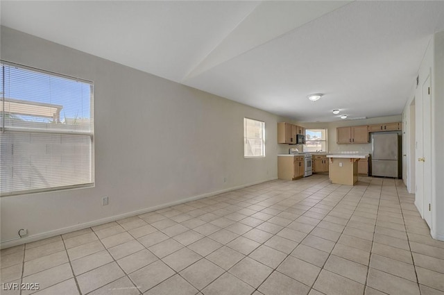 unfurnished living room featuring baseboards and light tile patterned floors