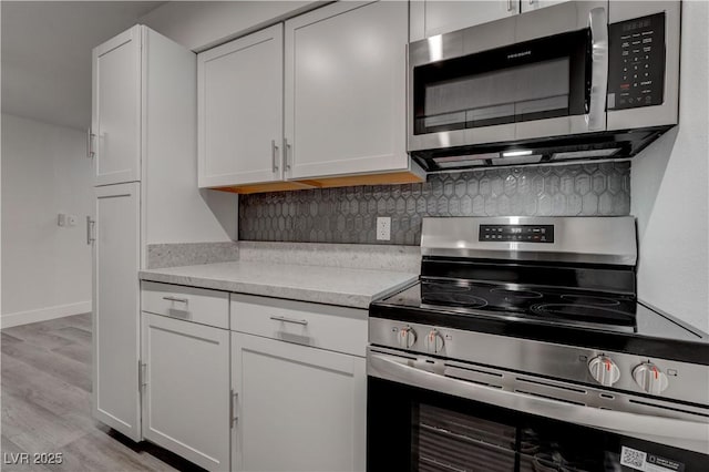 4432 Ash Ave, Las Vegas, NV 89110 - kitchen with decorative backsplash, light countertops, white cabinets, and appliances with stainless steel finishes