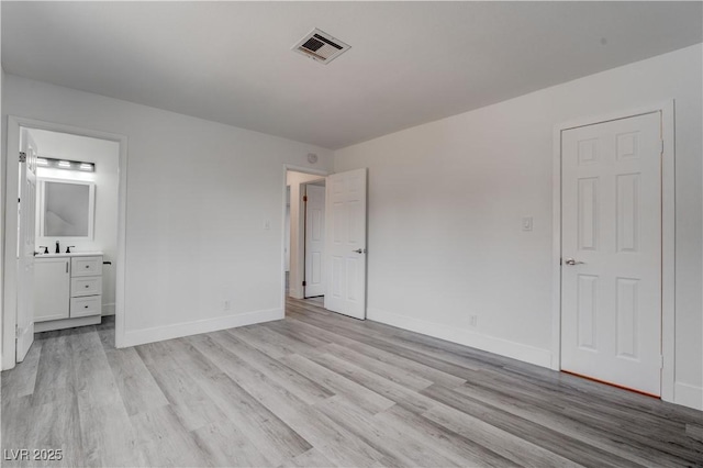 4432 Ash Ave, Las Vegas, NV 89110 - unfurnished bedroom featuring light wood-style flooring, connected bathroom, baseboards, and visible vents