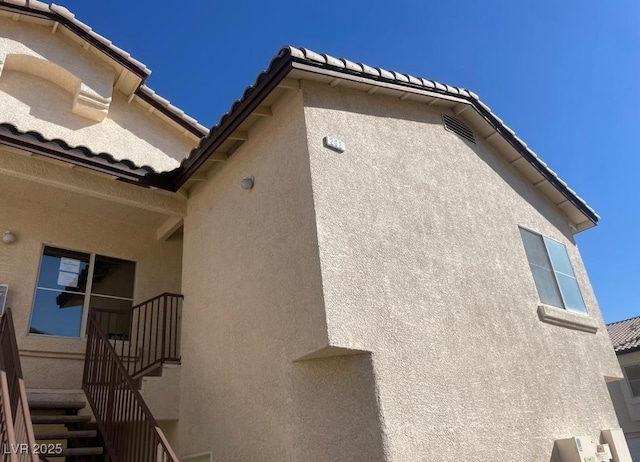 4941 Black Bear Rd Unit 202, Las Vegas, NV 89149 - view of home's exterior with a tiled roof, stairs, and stucco siding