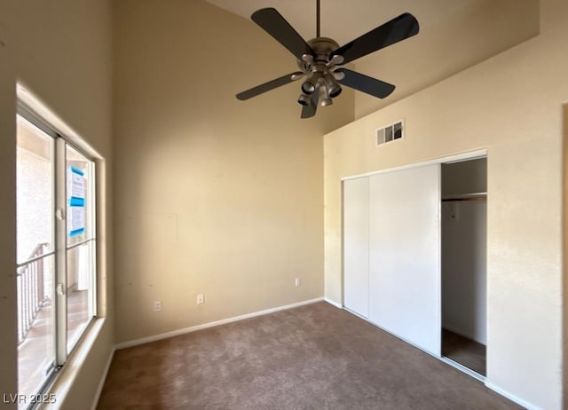 4941 Black Bear Rd Unit 202, Las Vegas, NV 89149 - unfurnished bedroom with visible vents, a closet, a towering ceiling, baseboards, and dark carpet