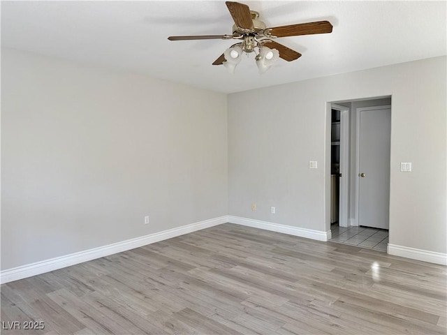 empty room with light wood-style floors, baseboards, and ceiling fan