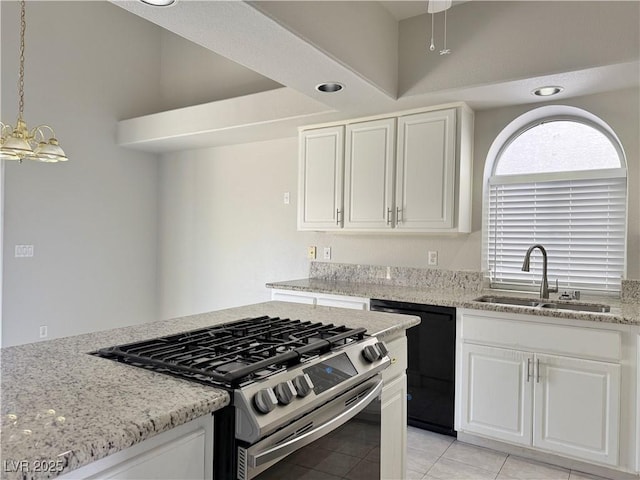 kitchen with stainless steel gas range, white cabinets, light stone counters, a sink, and black dishwasher