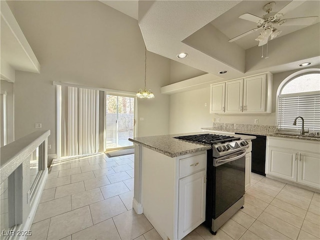 kitchen with stainless steel gas stove, light stone countertops, a high ceiling, recessed lighting, and a sink