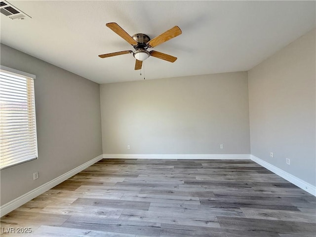 empty room featuring baseboards, a ceiling fan, wood finished floors, and visible vents