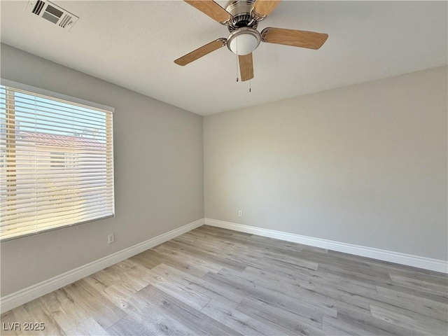 unfurnished room with visible vents, a ceiling fan, light wood-style flooring, and baseboards