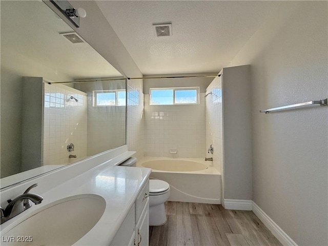 full bathroom with shower / bathing tub combination, wood finished floors, baseboards, vanity, and toilet