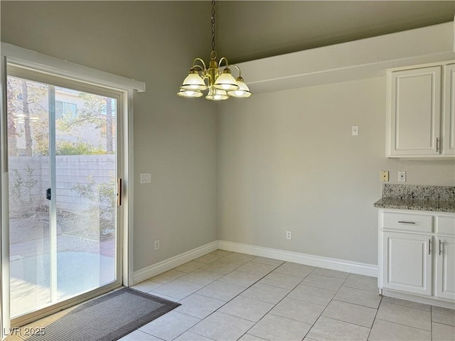 unfurnished dining area with light tile patterned flooring, baseboards, and a notable chandelier