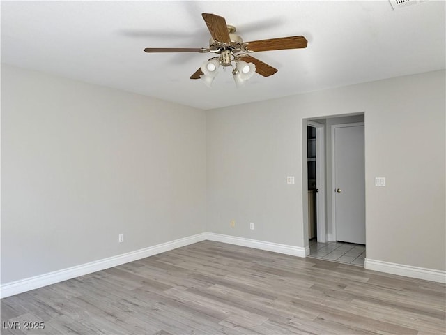 empty room with baseboards, light wood finished floors, and ceiling fan