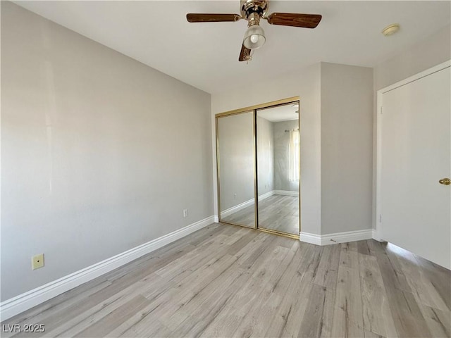 unfurnished bedroom featuring a closet, baseboards, ceiling fan, and light wood-style floors