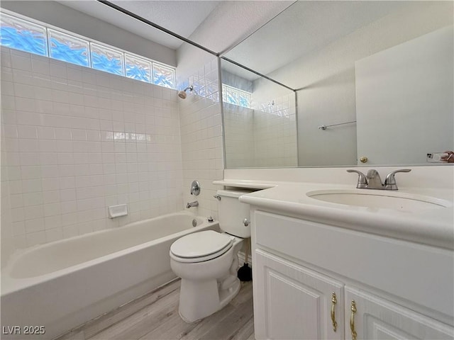 bathroom with shower / bath combination, wood finished floors, toilet, and vanity