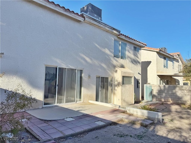 back of house featuring fence, a patio, stucco siding, and a tiled roof
