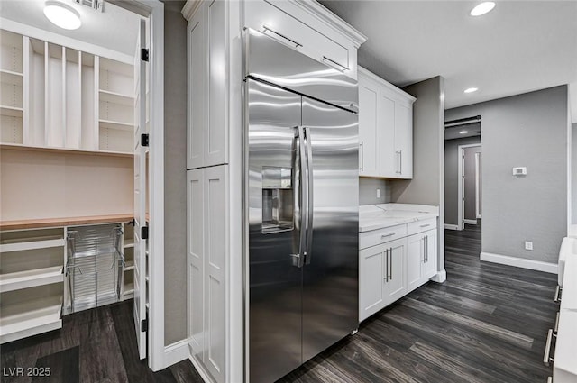 kitchen featuring built in fridge, recessed lighting, baseboards, white cabinetry, and dark wood-style floors
