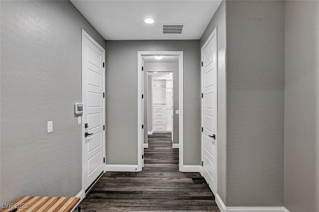 corridor with visible vents, recessed lighting, baseboards, and dark wood-style floors