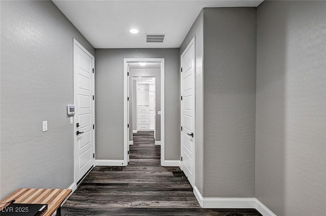 hallway featuring recessed lighting, baseboards, dark wood-style flooring, and visible vents