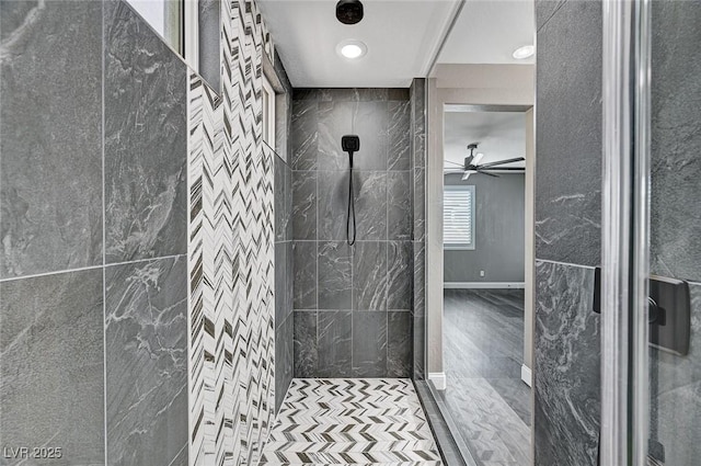 bathroom featuring a ceiling fan, tiled shower, and wood finished floors