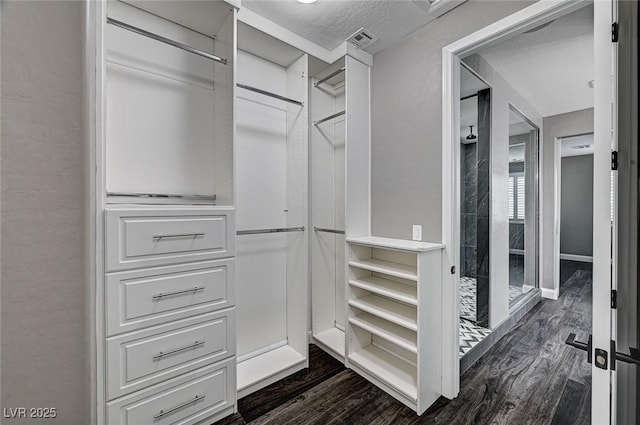 walk in closet featuring dark wood-style flooring and visible vents