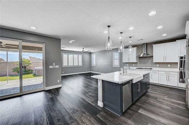 kitchen featuring wall chimney range hood, a ceiling fan, recessed lighting, and dishwasher