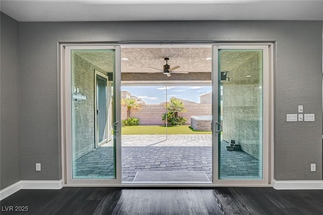 doorway to outside with baseboards, ceiling fan, and dark wood-style floors