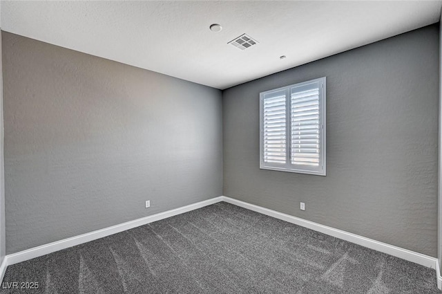empty room featuring baseboards, visible vents, and dark colored carpet